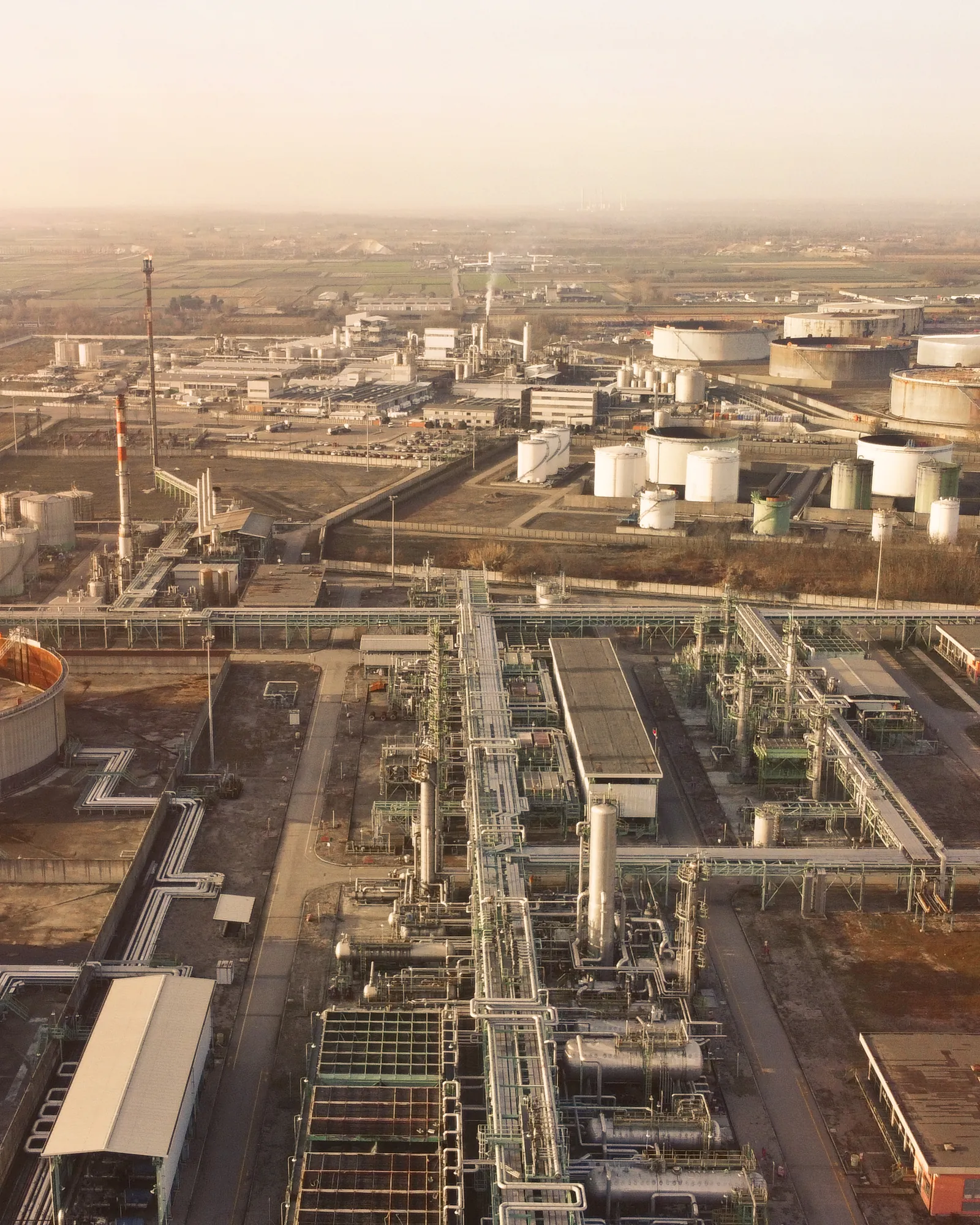 Aerial view of a large energy and chemicals plant with process units, pipe racks and storage tanks